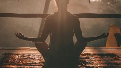 Person meditating peacefully at sunrise